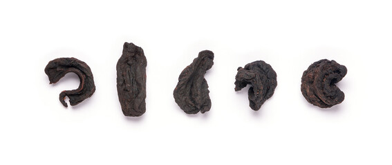 collection of sun dried garcinia fruits, black shriveled flavoring herb native to south asia, also known as brindle berry, goraka or malabar tamarind, on white 