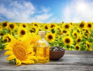 Sunflower oil with seeds and sunflower flower on wooden table