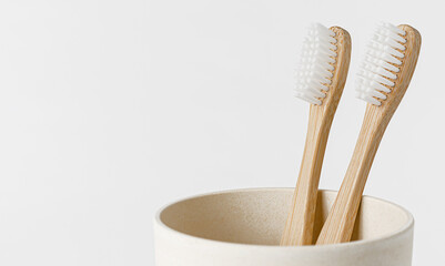 Bamboo toothbrushes in eco cup on white background. Copy space, close up. Ecological materials...