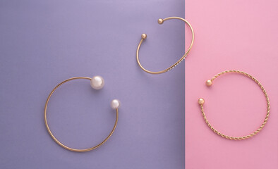Top view of modern bracelets collection on pastel colors background with copy space