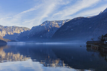 Alpine Hallstatt lake surrounded by mountains on sunny winter evening