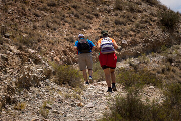 Elderly couple trekking through mountains in northern Argentina.