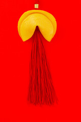 Chinese fortune cookie with red silk tassel on red background. Oriental traditional decorations. Concept Chinese New Year prosperity, luck and happiness