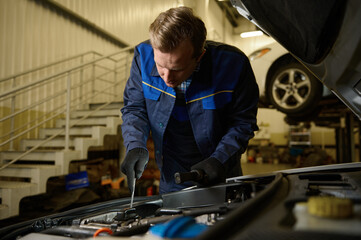 Professional technician, mechanic checking car engine. Auto mechanic hands using wrench to repair a car engine. Checking car service, repair, maintenance