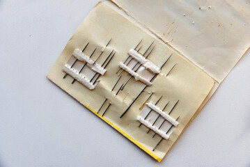 Old rusty needles in a paper set