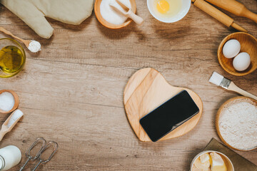Heart shape wooden board near ingridients for prepairing dough