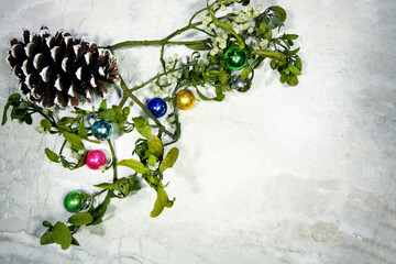 Mistletoe with ornaments, and a pine cone, flat lay with copy space.