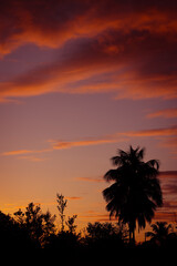 Obraz premium Impressive clouds of red and orange colors during sunrise on the beach.