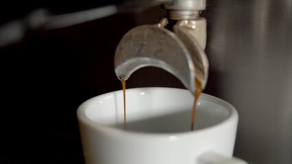 Espresso machine pouring coffee. Close up, looping cinemagraph of espresso dripping into coffee mug. Perfect loop, 4K.