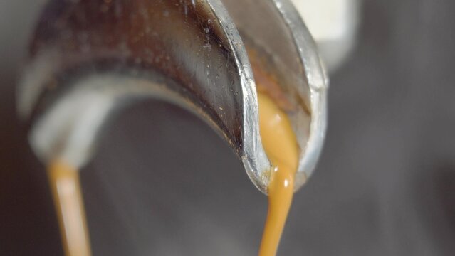 Espresso machine pouring coffee. Close up, looping cinemagraph of espresso dripping into coffee mug. Perfect loop, 4K.