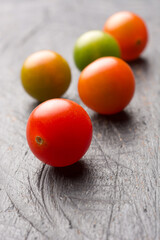Fototapeta na wymiar cherry tomatoes on a table top, closeup view taken in shallow depth of field with copy space
