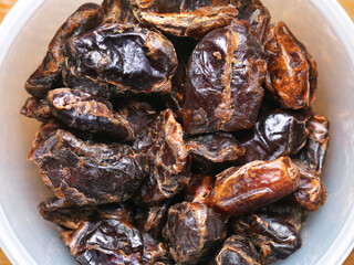A bowl of dried dates, top view macro close-up. 
