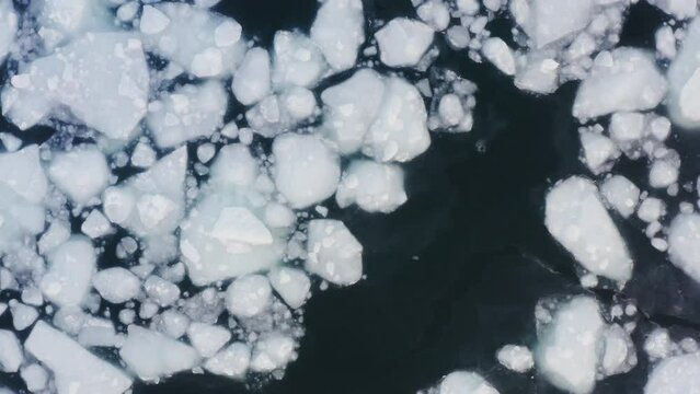 Drone view vertically down to frozen ice floes mixed with ice-free water