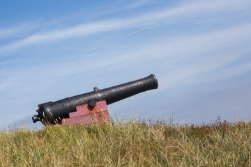 Large, old cannon on a meadow