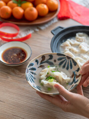 Holding a bowl of dumplings