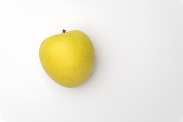 An isolated golden delicious apple with water beads on white background