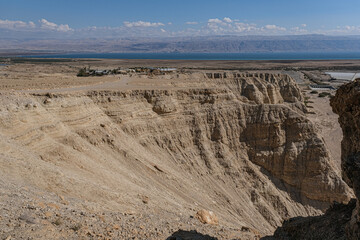 Fototapeta na wymiar View of Wadi Qumran and the Dead Sea in the background as seen from the trail high above the canyon, located on the northwestern shore of the Dead Sea, Qumran National Park, Israel.