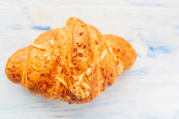 Croissant on a light wooden background. Photographed close-up.