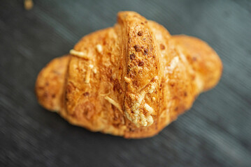 Delicious French croissant on a dark wooden background.