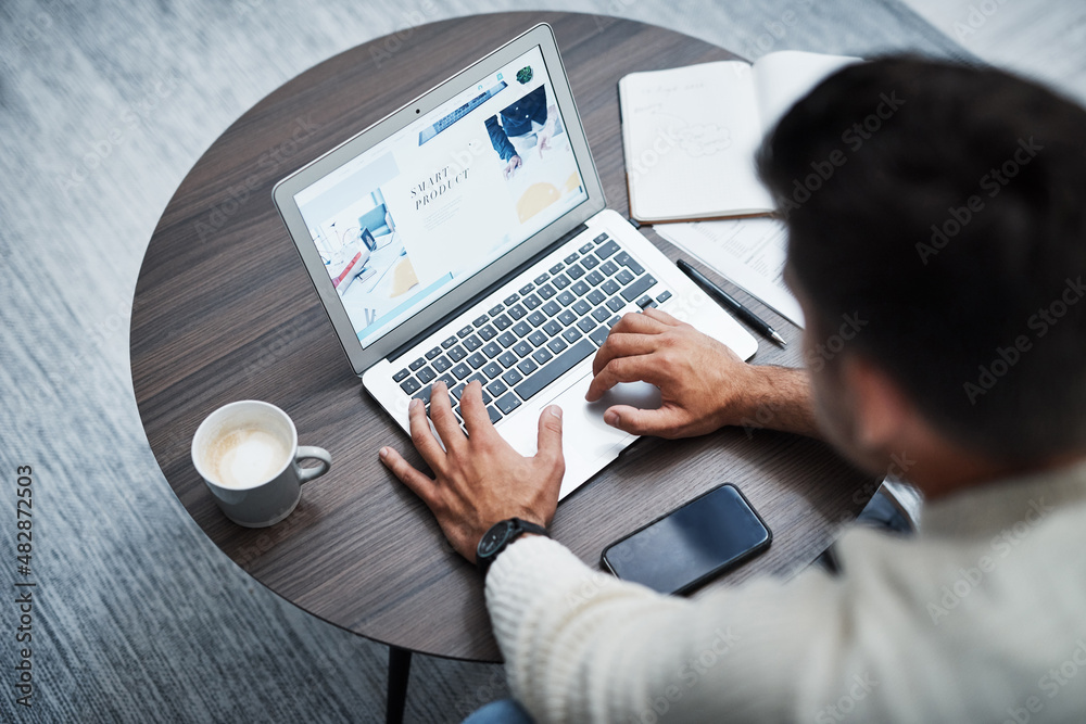 Poster home is where the office is. high angle shot of a young man using a laptop while working from home.