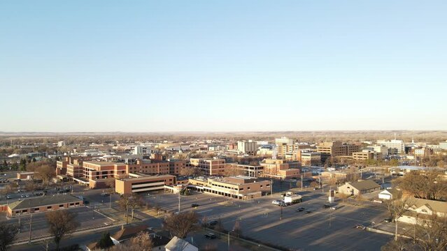 North Dakota community center on a bright sunny day. Multistory business complex with partially empty parking lot. Flat landscape in the distance. 