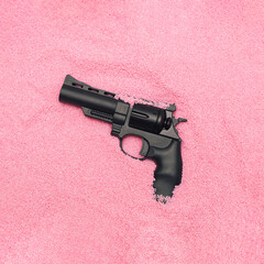 MInimal Valentine hate concept with weapon in pastel pink sand. Modern romantic aesthetic.