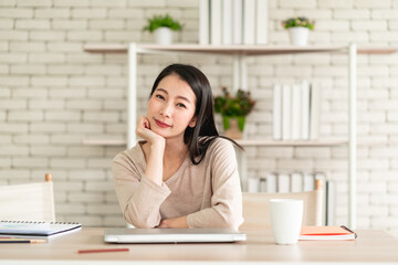 Beautiful young Asian woman wear surgical mask working from home and feeling happy smiling with joyful expression