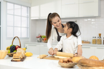 Happy asia family with daughter making dough preparing baking cookies, Daughter help parent preparing the bake Family concept