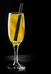 French 75 cocktail in a champagne flute on black background