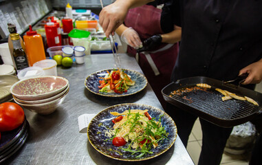 Professional chef cooking in the kitchen restaurant at the hotel, preparing dinner. serving food