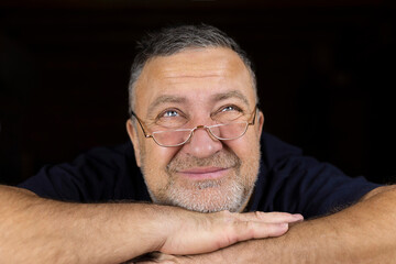 Fototapeta premium The face of a mature man with glasses with a strange look up. Soft focus.