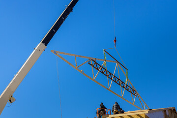 Wooden roof with crane holds a roof truss beams