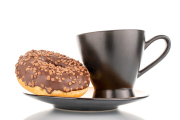 One sweet chocolate donut on a ceramic saucer with a black cup, macro, isolated on white.