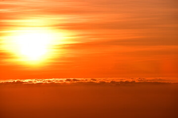 The sun set behind thick forests followed by mountains.