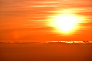The sun set behind thick forests followed by mountains.