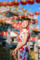 attractive Asian woman wearing traditional cheongsam qipao dress out door , Chinese new year concept