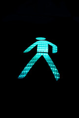close up of a green pedestrian traffic light at night