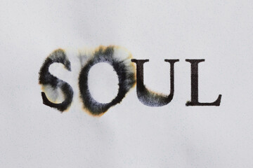 Type of the word "SOUL" is written on a paper crumpled background with ink drips on paper. Concept of soul preservation