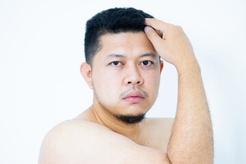 Obraz premium Portrait of shirtless Asian man showing his muscle, standing isolated on white background.