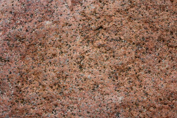 Texture of a brown granite stone. The background of the material granite mineral stone. Rough drawing of granite surface, natural mineral stone wall background
