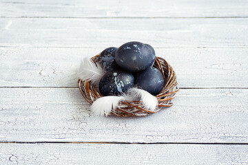 Eggs in a decorative white nest are painted for Easter celebration. Festive decor for breakfast