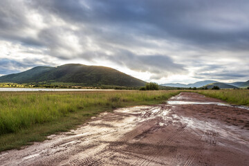 Landscape view of a lake surrounded by mountains and green savanna grassland, Pilanesburg Nature Reserve, North West Province, South Africa