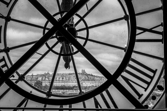 View of church Sacre Coeur in Montmartre through a large Clock from Museum d'Orsay in Paris