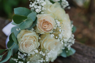 Wedding bouquet of fresh flowers, a pair of gold rings close-up. Wedding details