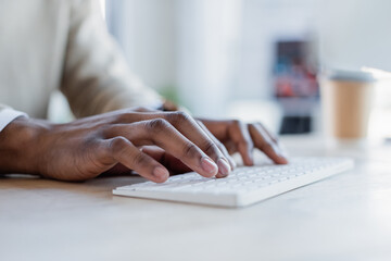 partial view of african american man typing on computer keyboard.