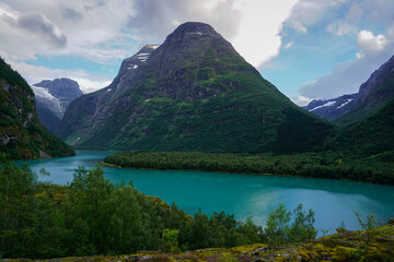 Beautiful Norwegian mountains landscape, in the background the Kjenndal Glacier in Jostedalsbreen National Park. The azure color of the lake's water
