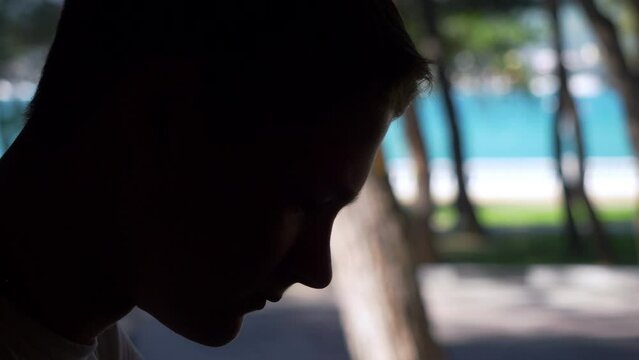 Silhouette of a teenager with sad expression face close up. Depression and loneliness concept