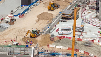 Excavators and bulldozers working at construction site of new skyscraper aerial timelapse. © HyperlapsePro