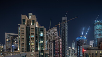 Fototapeta na wymiar Panorama showing aerial cityscape night timelapse with illuminated architecture of Dubai downtown.