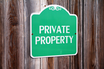 Private Property green and white sign on a wooden fence
